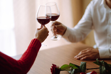 Clinking glasses with red wine. Romantic dinner. Valentines day, romantic date and holidays concept.