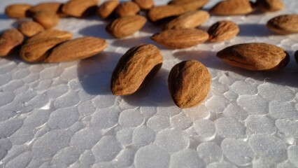 Many brown almonds isolated on white background. heap of Indian, Asian almond (Prunus dulcis).