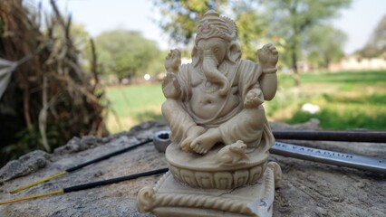 Fototapeta na wymiar White statue of lord ganesha in sitting action with marble stone. The Lord of all wisdom and knowledge
