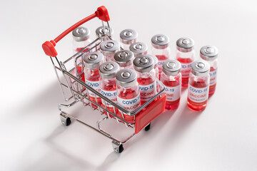 Wire shopping cart with vaccine vials bottles for vaccination against COVID-19 SARS-CoV-2...
