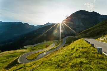 Motorbiker riding in Austrian Alps in beautiful sunset dramatic sky. Travel and freedom, outdoor activities