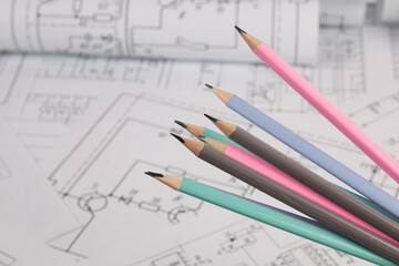 Engineering pencils on background of electrical engineering drawings.