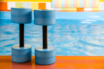 dumbbells equipment for aqua aerobics sport near swimming pool
