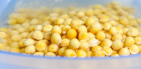 Yellow soaked peas in water close-up in a cup. Macro.