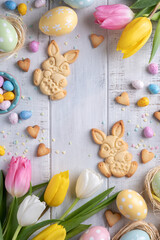 Happy easter background with bunnies, eggs, candies flowers