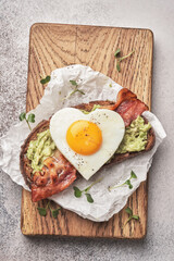 Heart shape Fried egg sandwich with avocado and bacon