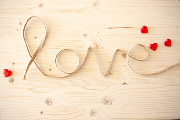 Word "love" made with rope on wooden background