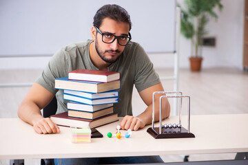 Young male student preparing for exams in the classroom