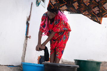 African nice woman hand washing laundry outdoors