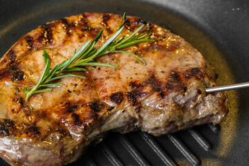 Fried beef steak in the grill pan with rosemary. Healthy dinner concept. 