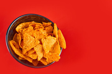 Bowl of crispy chips on red background