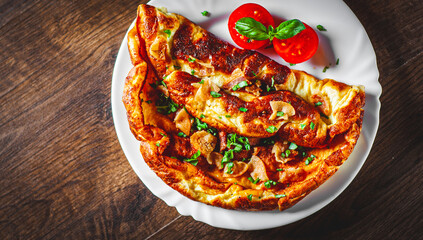 omelette with bacon in a white plate on wooden table