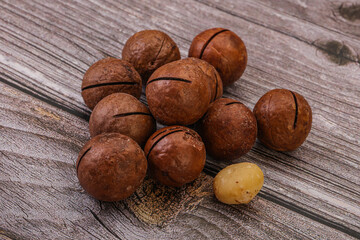 Brown macadamia nut heap over background