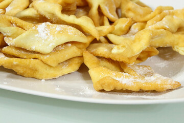 Fresh biscuits brushwood on a white plate on the table. Close-up. Background.