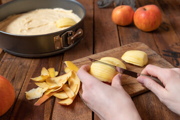 Vorbereitung zum Backen eines Kuchens mit Obst in der Küche mit Utensilien Springform, Teig und...