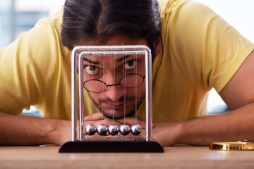Young male student physicist preparing for exams in the classroom