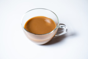 Clear glass of milk coffee on white background