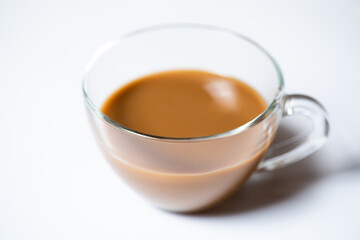 Clear glass of milk coffee on white background