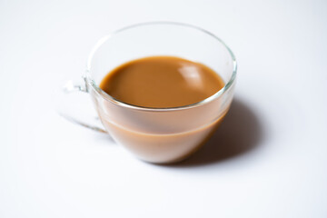 Clear glass of milk coffee on white background