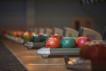 Graphic background image of ball return machines and bowling ball in row at entertainment center, copy space