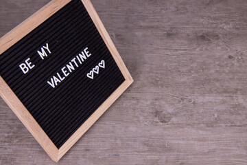 A sign that says Be My Valentines on a wooden background