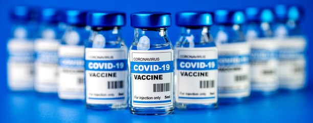 covid-19 vaccine - coronavirus vaccination bottles. injection vials on blue background - obrazy, fototapety, plakaty