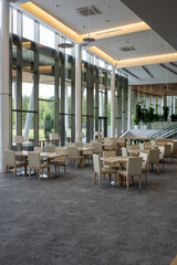 Interior of five star restaurant inside modern business center with many tables