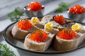 Sandwiches with red caviar and butter on the plate