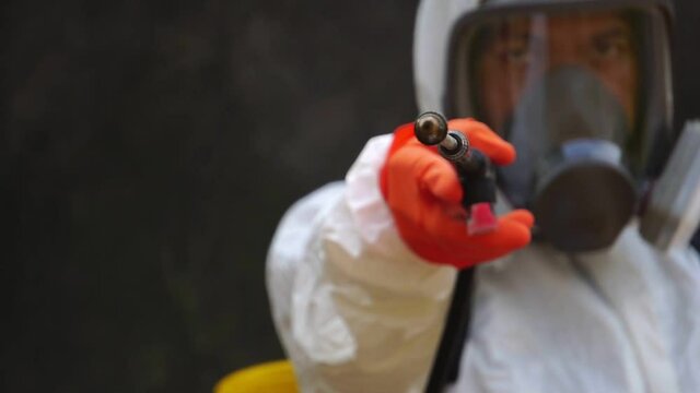 Footage Slow Motion: A male expert is spraying a cleaning solution to prevent COVID-19