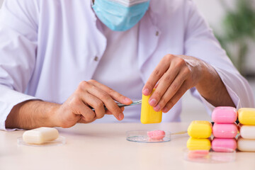 Obraz na płótnie Canvas Young male chemist testing soap in the lab