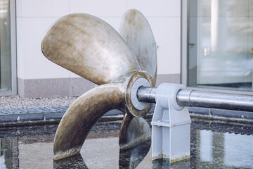 Gray iron ship propeller on the water