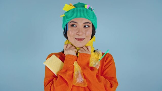 Portrait of funny asian woman choking herself by yellow  raincoat.