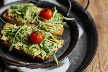 Toast with avocado, arugula and cherry tomatoes