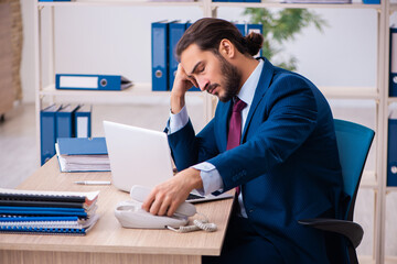 Obraz premium Young male employee and too many work in the office