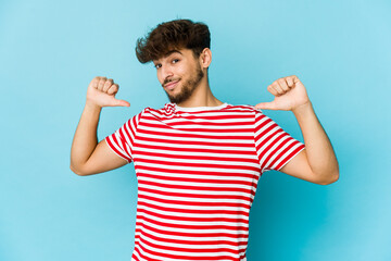 Young arab man on blue background feels proud and self confident, example to follow.