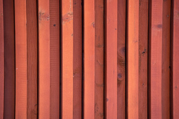 the texture of a red wooden wall made of repeating boards