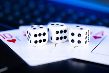 Online gaming platform, casino and gambling business. Cards and dice on laptop keyboard, toned in blue