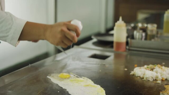 Image Of A Chef Hands Cracking An Egg In A Griddle Plate At Kitchen Restaurant. - Close Up, Slow Motion