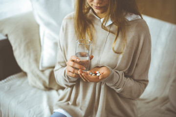 Close-up woman holding pills time to take medications, cure for headache, high blood pressure or...