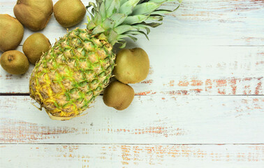 Tropical fruits on rustic white table, pineapple and kiwis.
