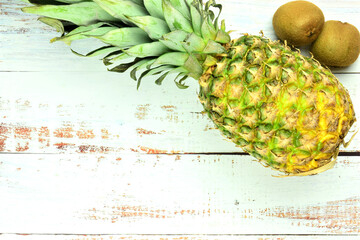 Tropical fruits on rustic white table, pineapple and kiwis.