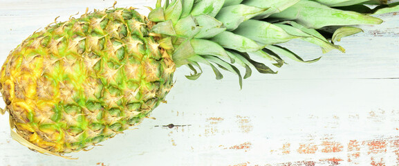 Pineapple, tropical fruit on rustic white table. Copy space. Large rectangular format.