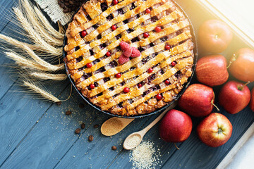 Apple pie with golden crust fresh apples and decor on the table	

