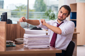 Young male employee and too many work in the office