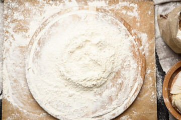 white wheat flour heaped on a round wooden board