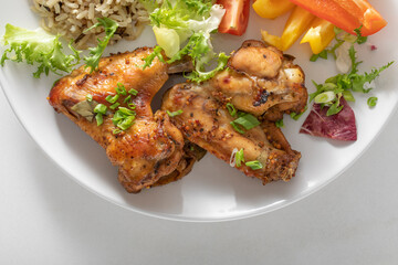 plate of baked chicken wings on a white background.