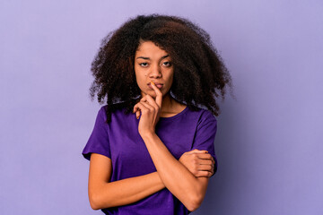 Fototapeta na wymiar Young african american curly woman isolated on purple background unhappy looking in camera with sarcastic expression.