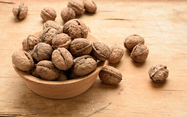 bunch of walnuts in a wooden plate on the table