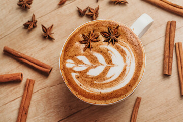 Spicy cappuccino with star anise and cinnamon in cafe.