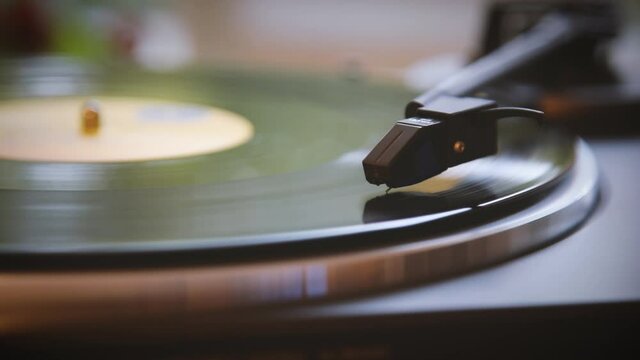The vinyl record is spinning. The needle plays on a vintage vinyl record. Old turntable. Vintage